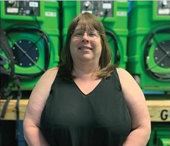 Woman standing in front of a green SERVPRO background.
